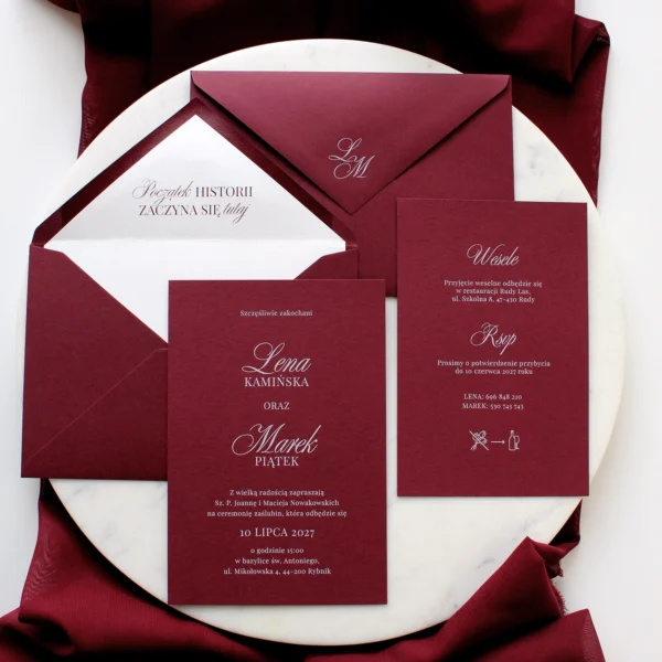 elegancki komplet papeterii ślubnej w głębokim odcieniu czerwonego wina z białym nadrukiem i kopertą z monogramem