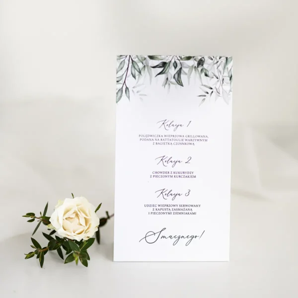Detal tylnej strony menu weselnego z zielonym motywem liści.