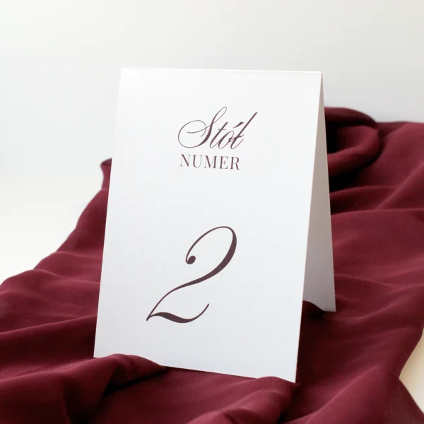 śmietankowa tabliczka z numerem stołu weselnego w burgundowej kolorystyce