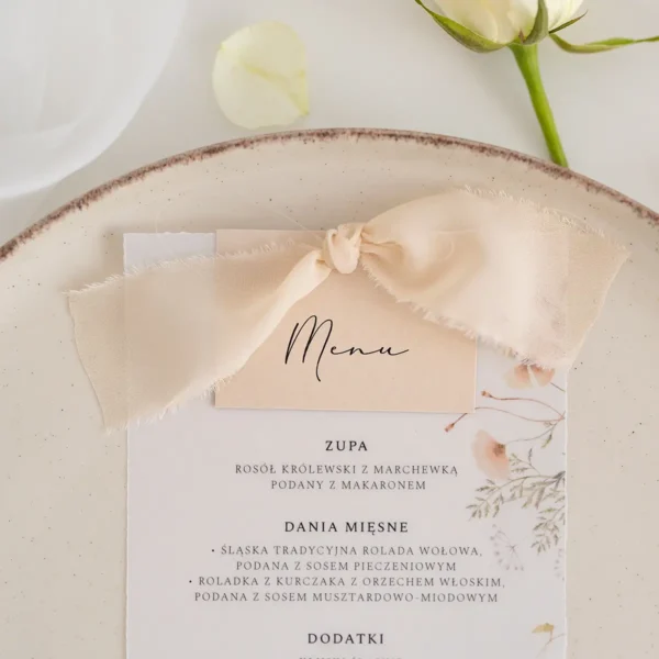 Stylowe menu weselne z kaligraficznym napisem, dekorowane szarpanym szyfonem w odcieniu beżu.