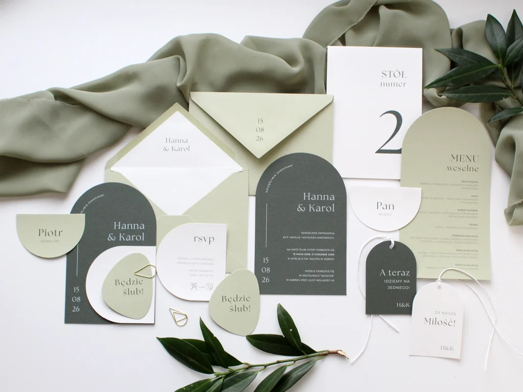 Komplet papeterii ślubnej Jungle w zielonej kolorystyce, obejmujący zaproszenia, winietki, menu i numer stołu.