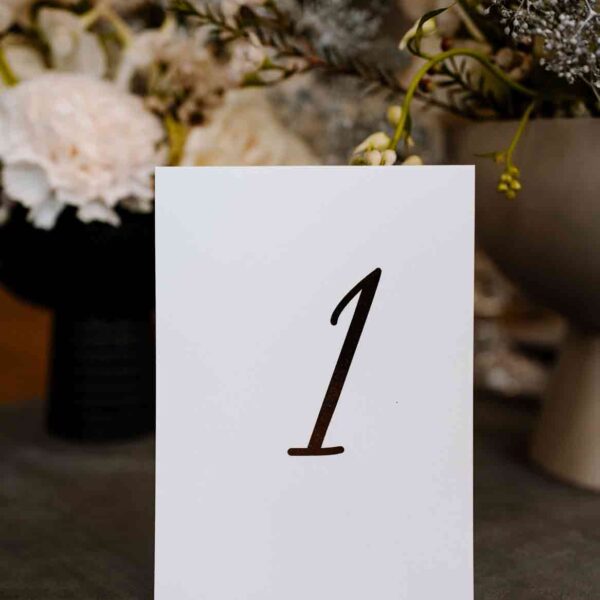 Złoto-białe numery stołów weselnych.