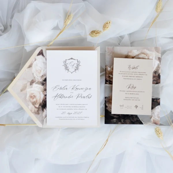 Beżowa karta RSVP i białe zaproszenie ślubne z monogramem i kopertą z kwiatową wkładką – wszystko utrzymane w stylu vintage.