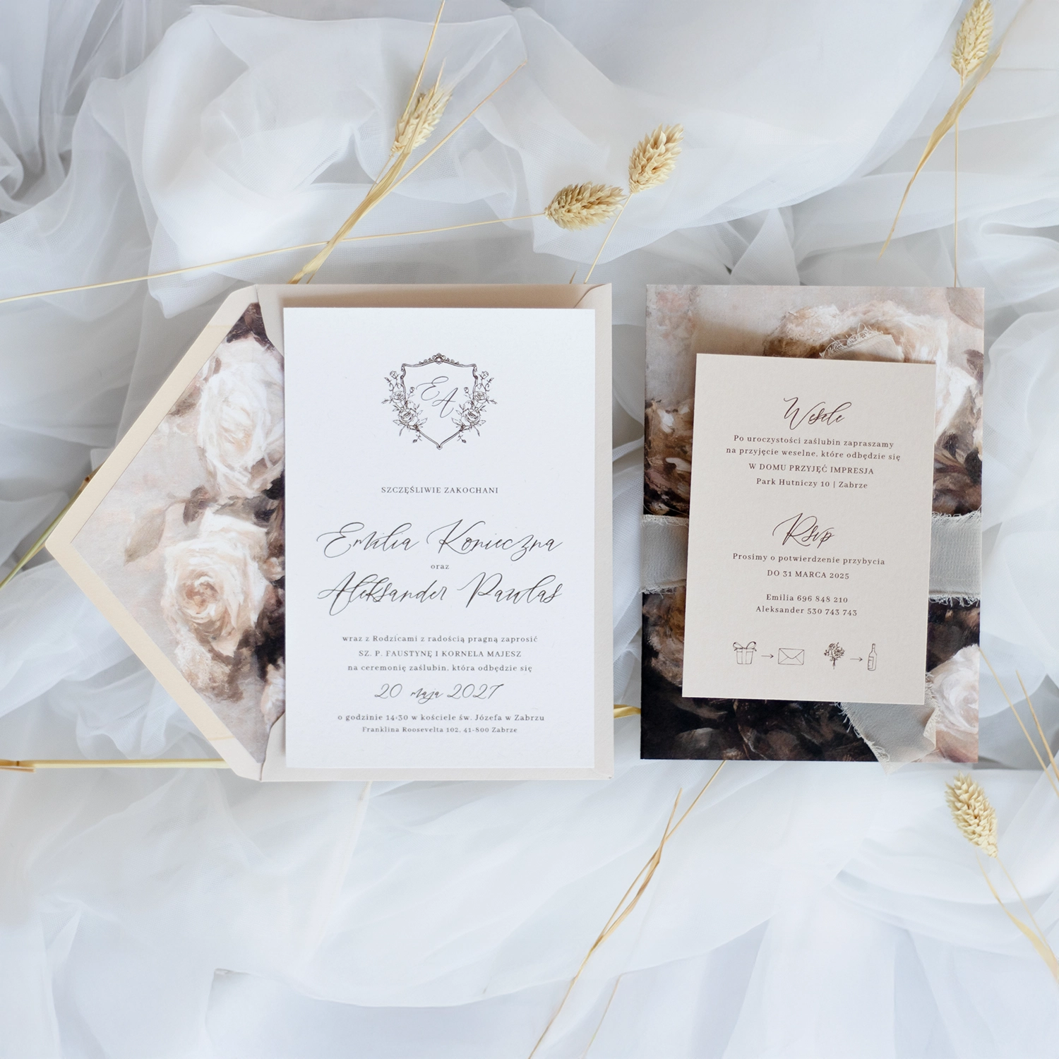 Beżowa karta RSVP i białe zaproszenie ślubne z monogramem i kopertą z kwiatową wkładką – wszystko utrzymane w stylu vintage.