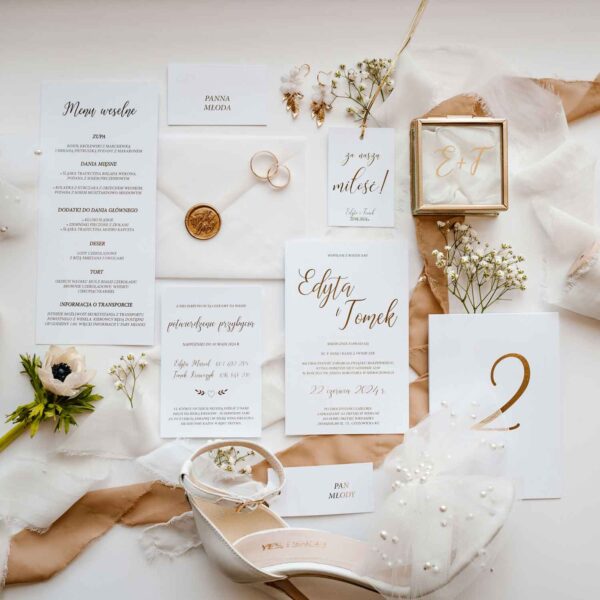 Zawieszka w kolorze białym ze złotym napisem z lakiem.