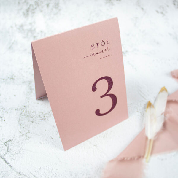 Numer stołu w kolorze brudnego różu i ozdobną czcionką