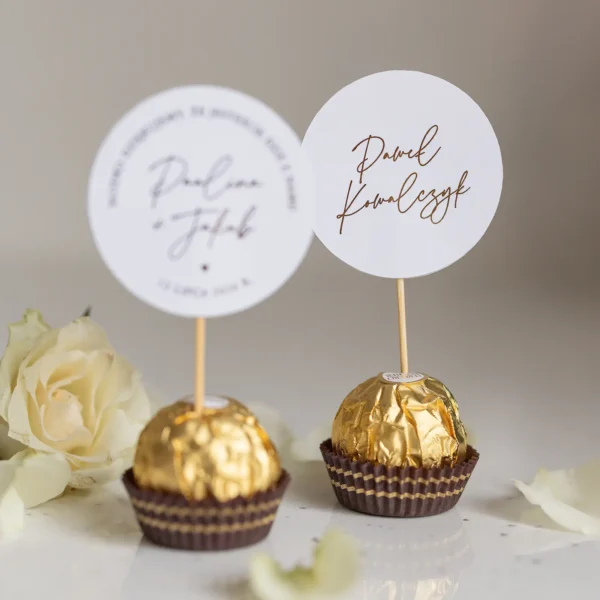 Podziękowania dla gości – Ferrero Rocher z okrągłym bilecikiem ze złotym napisem, dekoracja na wesele.