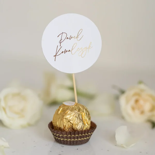 Okrągła winietka z imieniem na czekoladce Ferrero Rocher, elegancki dodatek do aranżacji stołu ślubnego.