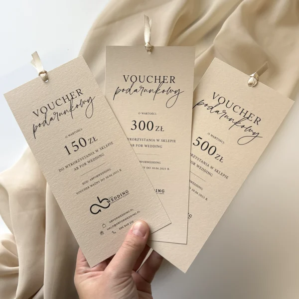 zestaw trzech voucherów podarunkowych AB for Wedding o różnych nominałach, ozdobionych delikatną wstążką