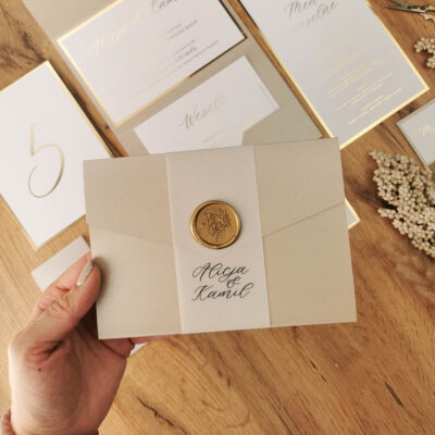 Folder z złota minimalistycznym zaproszeniem z podklejką z lakiem.
