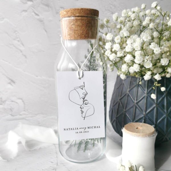 Biała zawieszka z zarysami twarzy na alkohol