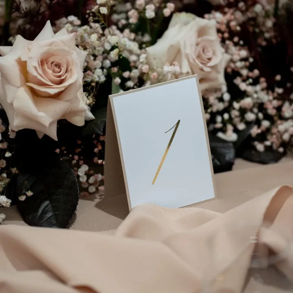 Luksusowe numery stołów weselnych z kolekcji Złoty Folder, w stylu glamour z połyskującymi detalami.