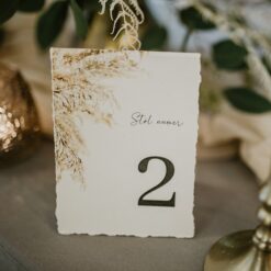 Numer stołu na wesele z wzorem trawy pampasowej.