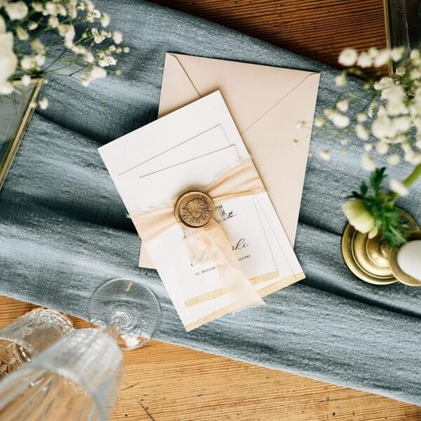 Zaproszenie ślubne z wzorem zamku z lakiem oraz szarpaną wstążką.