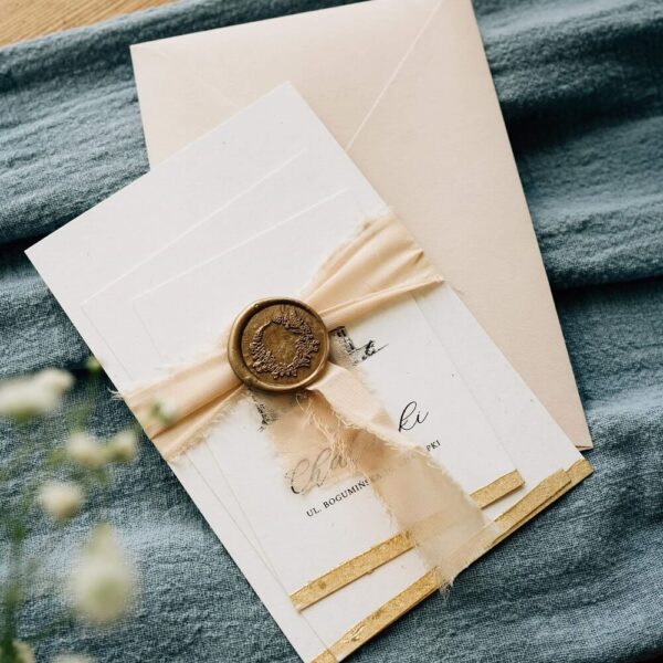 Zaproszenie ślubne z grafiką zamku z lakiem oraz szarpaną wstążką.