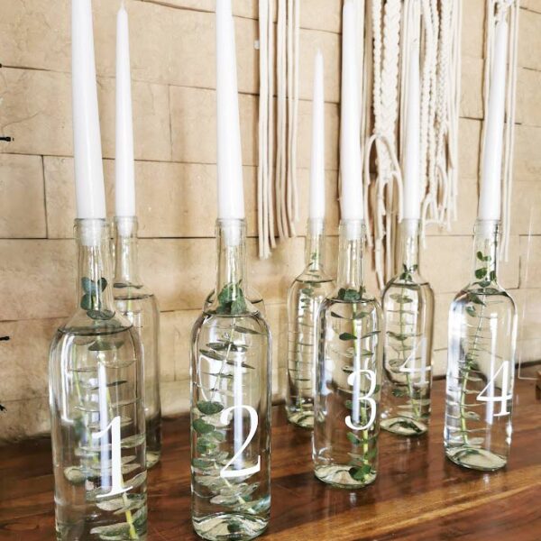 Świecznik w butelce z eukaliptusem, numery stołów na wesele