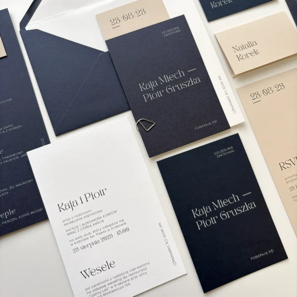 Zbliżenie na główne zaproszenia z kolekcji Navy Blue – granatowe, beżowe i białe karty z minimalistycznym nadrukiem.