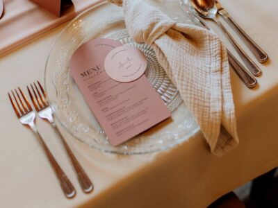 Menu weselne podane gościom na przejrzystym talerzu w kolorystyce zgaszonego różu