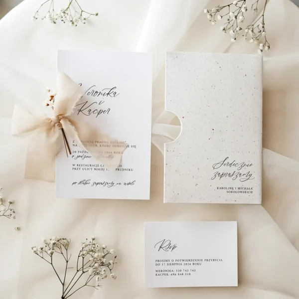 Eleganckie zaproszenie ślubne z kolekcji Glixia, ozdobione delikatnym motywem kwiatowym i przewiązane szyfonową wstążką.