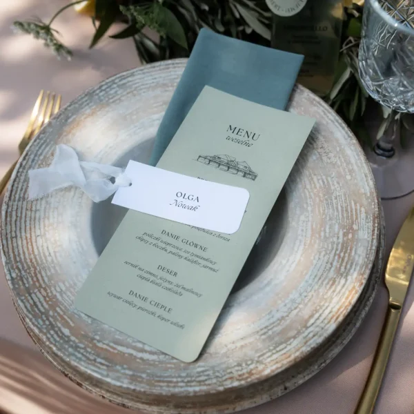 Menu weselne z imienną winietką, elegancko ułożone na rustykalnym talerzu.