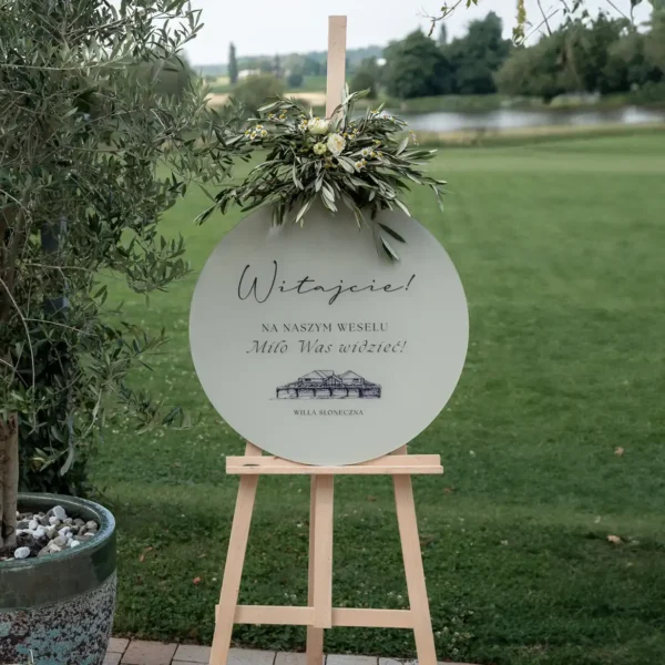Okrągła tablica powitalna z rysunkiem Willi Słoneczna