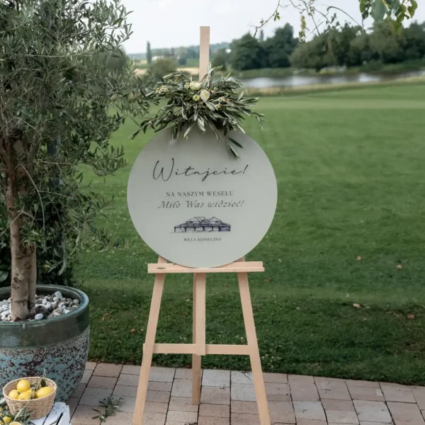 Okrągła tablica powitalna z rysunkiem Willi Słoneczna