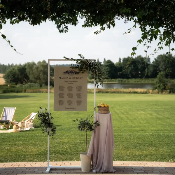 Plan stołów w plenerze na tle malowniczej scenerii wiejskiej, z cytrynami i oliwkami.