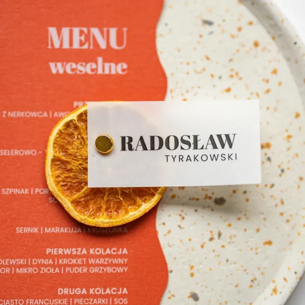 Półprzezroczysta winietka z suszoną cytryną z zestawu Sycylia na tle menu weselnego