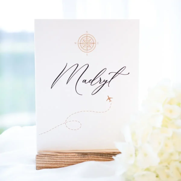 Numer stołu z nazwą miasta "Madryt" i motywem samolotu, kolekcja podróżnicza.