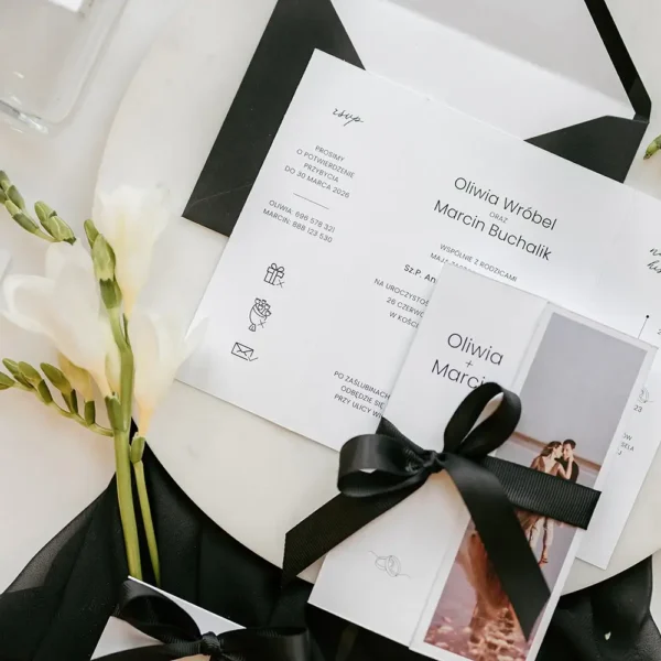 Eleganckie zaproszenie ślubne ze zdjęciem i ozdobną wstążką.