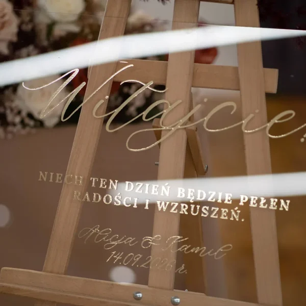 Luksusowa tablica powitalna z kolekcji Złoty Folder, ozdobiona złotymi napisami na plexi.