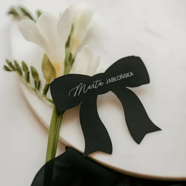 Czarna winietka kokardka na białym tle. Oryginalny i elegancki detal, który doda charakteru każdej uroczystości.