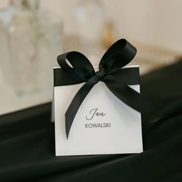 Ozdobna winietka z kokardką, idealna na eleganckie przyjęcia. Subtelny dodatek, który podkreśli wyjątkowy charakter wydarzenia.