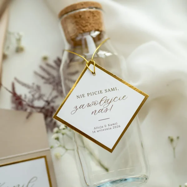 Elegancka zawieszka na butelkę z kolekcji Złoty Folder, ozdobiona złoconym brzegiem i subtelną kaligrafią.