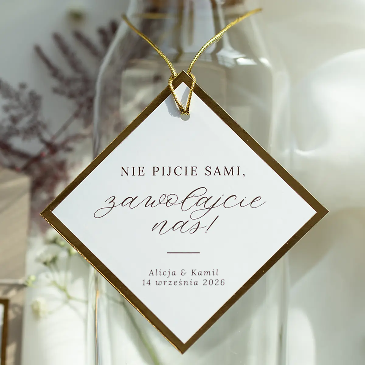 Ekskluzywna zawieszka na butelkę z kolekcji Złoty Folder, z bogatym złoceniem i finezyjną typografią.