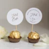 Winietki na komunię na pralinkach Ferrero Rocher z personalizowanym topperem na patyczku.