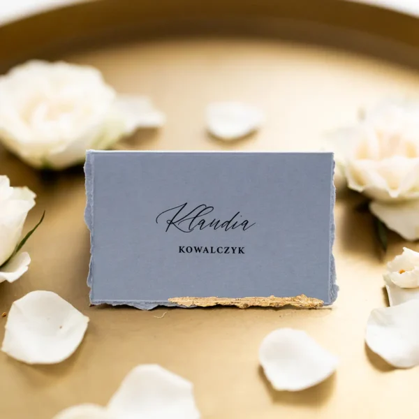 Niebieskie winietki na komunię z ręcznie postrzępionymi brzegami i złoconym detalem.