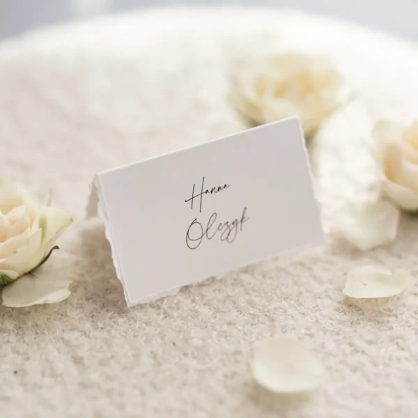 Klasyczna biała winietka komunijna w formie daszka, z eleganckim ręcznie szarpanym brzegiem.