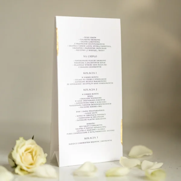 Menu weselne w formie stojącej karty z eleganckim układem tekstu i złotym detalem na białym tle