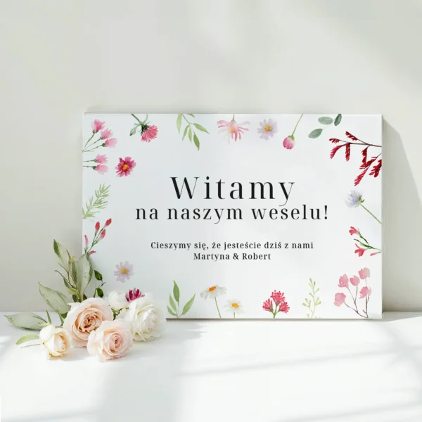 Tablica powitalna na wesele z kolorowymi kwiatami i napisem "Witamy na naszym weselu"