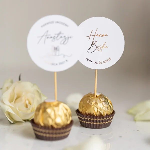 Winietka na roczek – pralinka Ferrero Rocher ozdobiona topperem z napisem i symbolem prezentu.