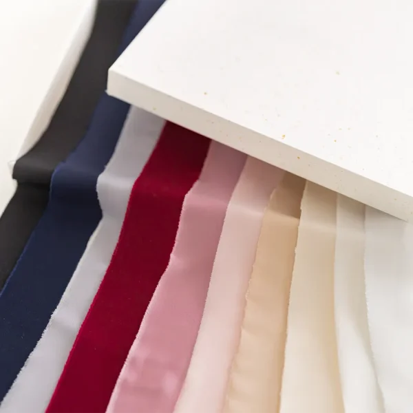 Rwana wstążka satynowa pokazująca strukturę materiału na tle białego papieru.