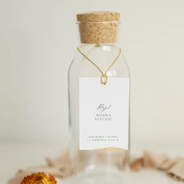 Butelka z zawieszką na alkohol z napisem „Pij! Wódka stygnie!”, na tle kremowej tkaniny, z kolekcji Zamek Chałupki