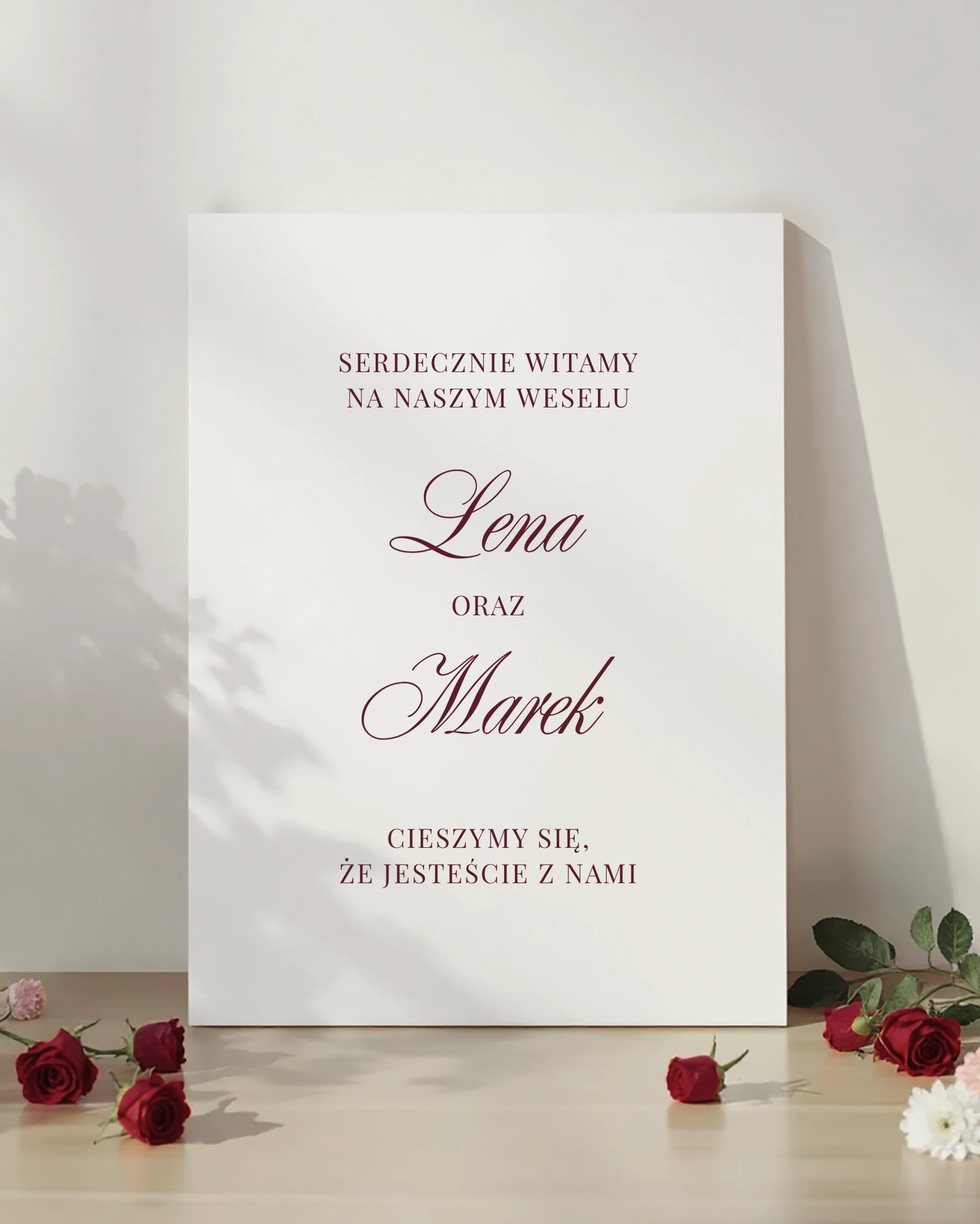 tablica powitalna burgundowa z napisem „Serdecznie witamy na naszym weselu” z dekoracją z czerwonych róż