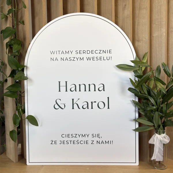 Prostokątna tablica powitalna z kolekcji Jungle w odcieniach bieli i zieleni, z napisem „Witamy serdecznie na naszym weselu!”.