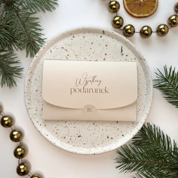 beżowy voucher świąteczny z napisem wyjątkowy podarunek na talerzu w otoczeniu gałązek świerku