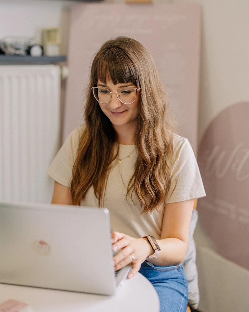 osoba pracująca przy laptopie podczas konsultacji dotyczących tworzenia zaproszeń DIY