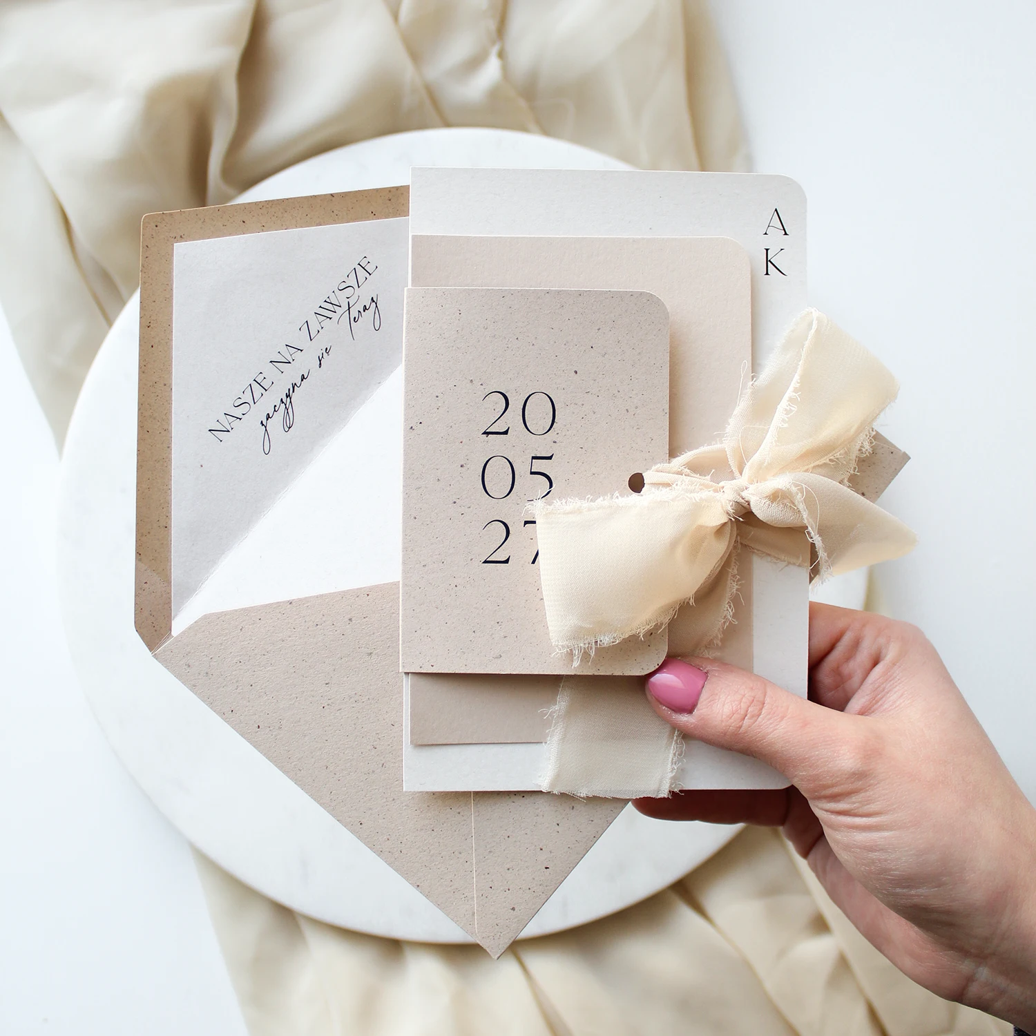 Papeteria ślubna w neutralnych barwach z szarpana wstążką