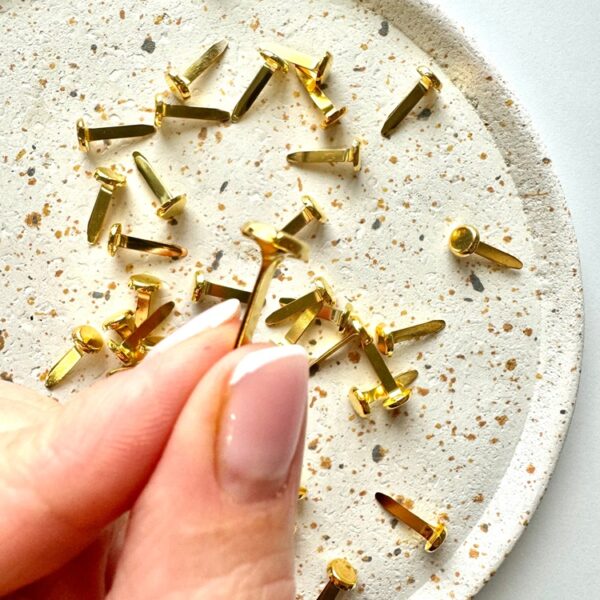 Mini złączki do winietek trzymane w dłoni – detal produktu