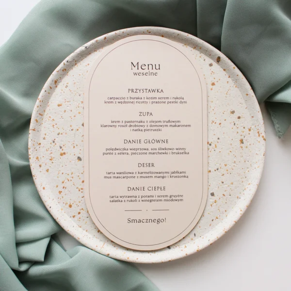 menu weselne Eukaliptus w kolorze beż z elegancką typografią i zaokrągloną formą, wyeksponowane na talerzu